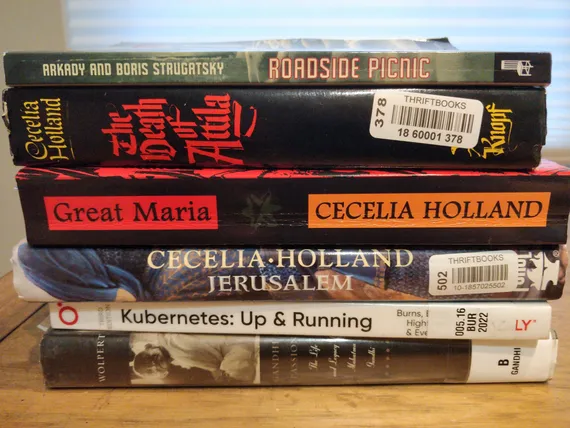 A stack of books on a shelf, most of which are mentioned in this post