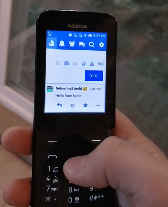 Photo of my hand holding a Nokia 8110 4G running Pinafore on KaiOS